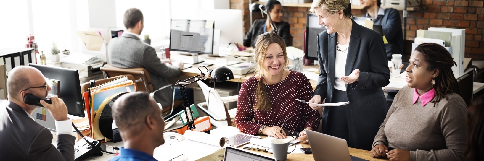 employees working in small office smiling