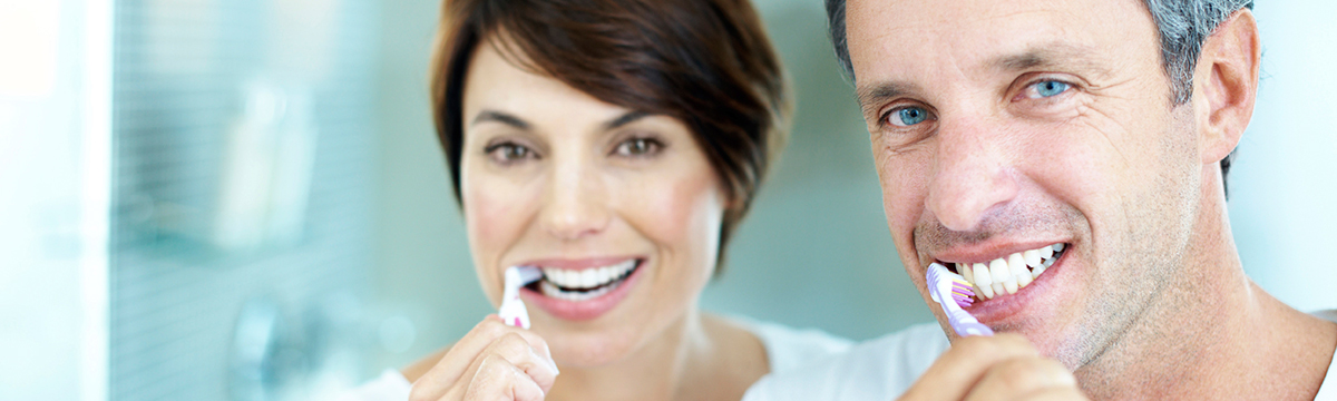 man and woman brushing teeth