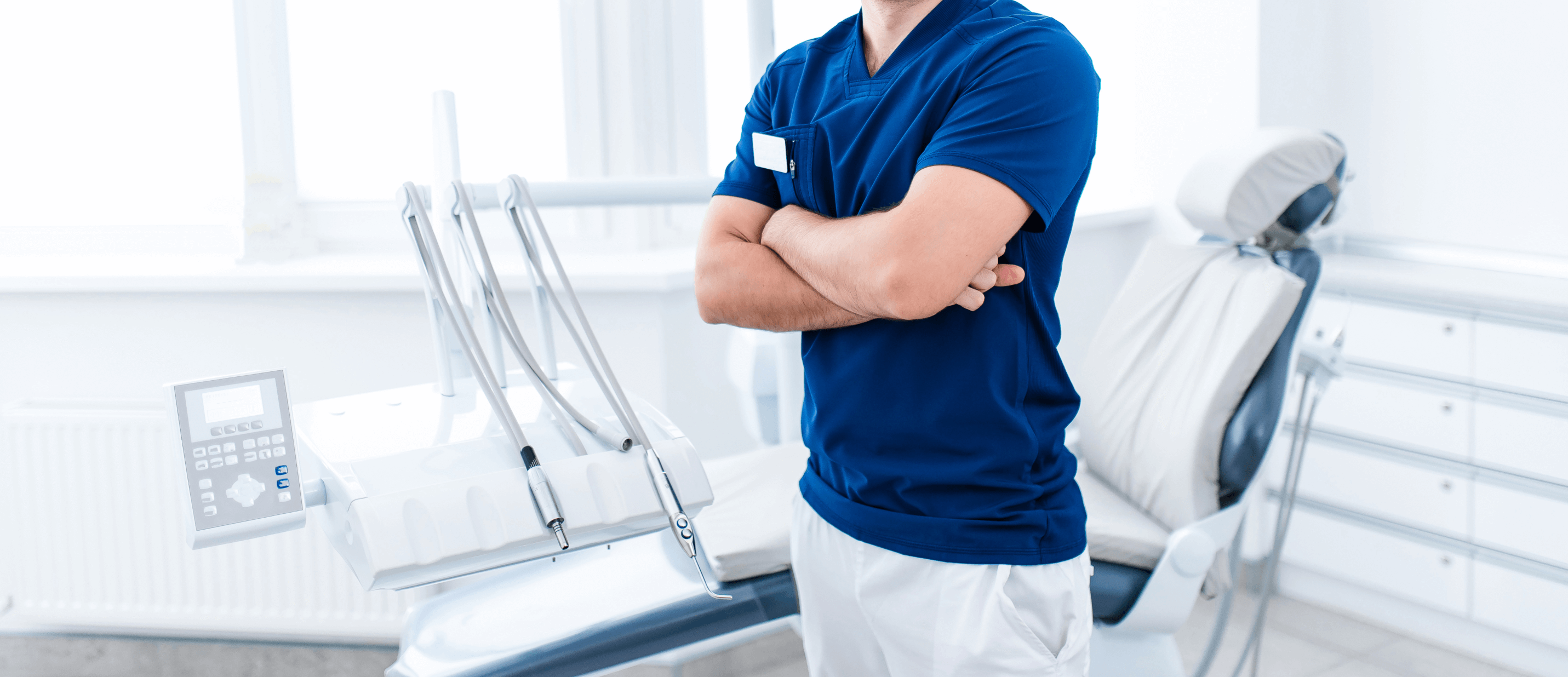 dentist standing in office with arms crossed